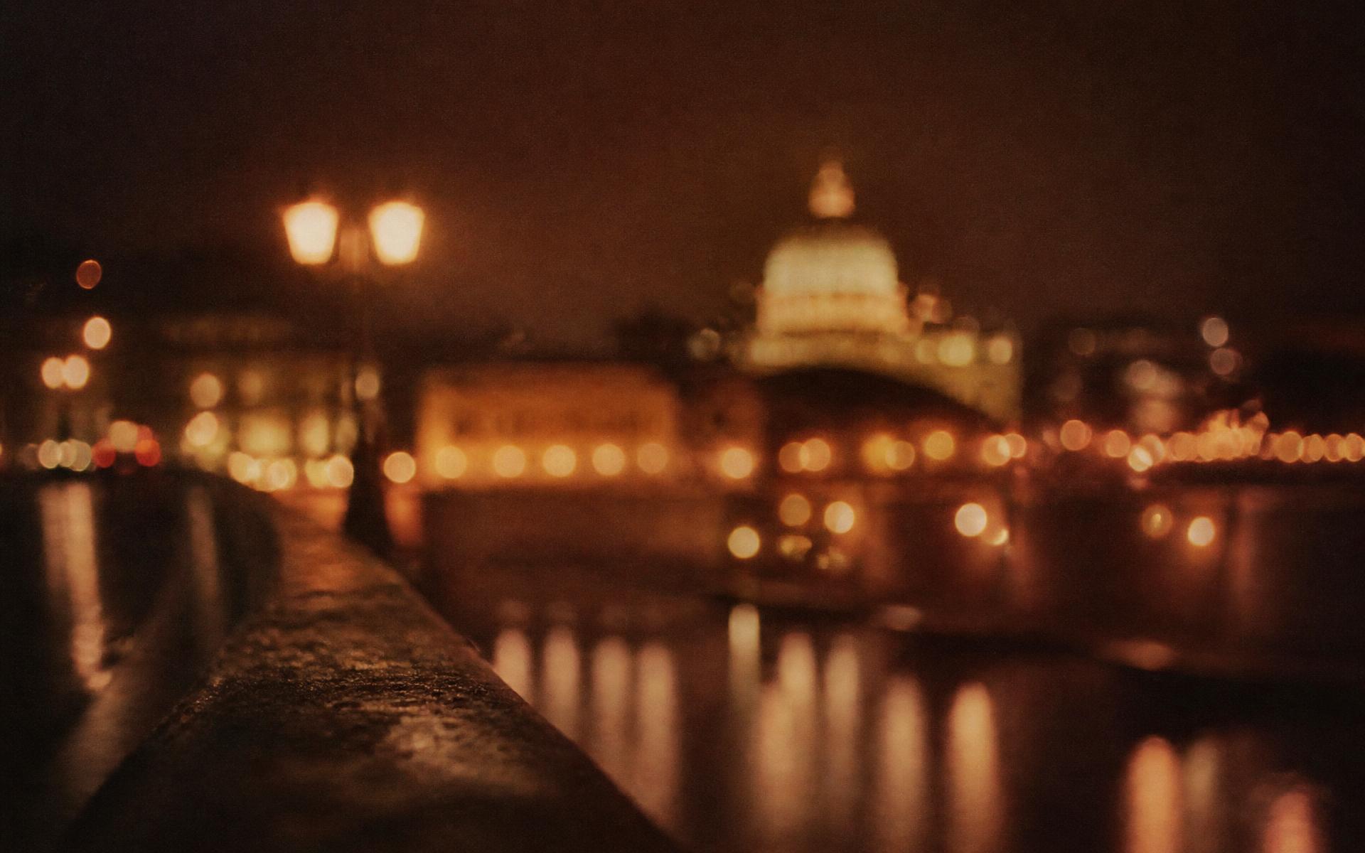 Blurred warm city lights reflecting on water at night